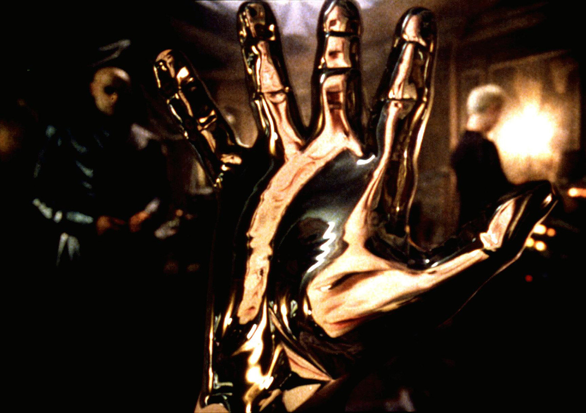 Neo touches the liquid chrome mirror — the moment of symbiosis